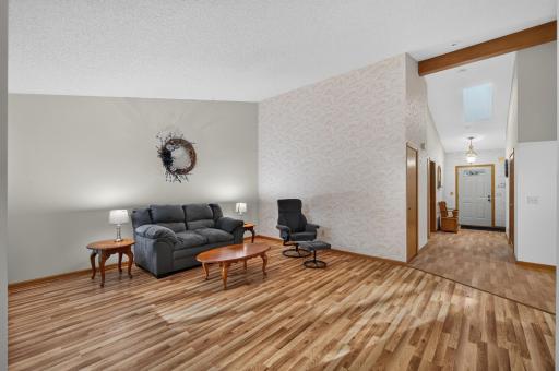 Natural light pours through big windows and multiple skylights, highlighting vaulted ceilings, natural woodwork and a warm, inviting floor plan.