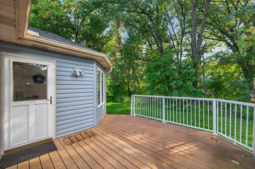 The den opens to the patio. The deck overlooks a beautiful green backdrop.