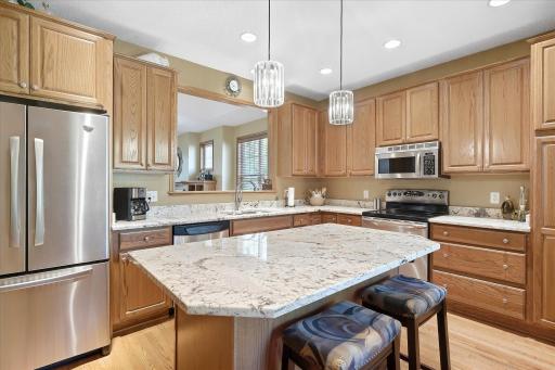 Beautifully renovated eat-in kitchen featuring granite countertops, stainless steel appliances, hardwood floors, and a spacious center island!