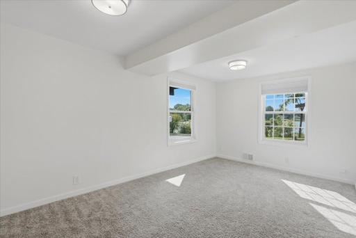 Light and bright lower level bedroom with new light fixtrue, paint and carpet.