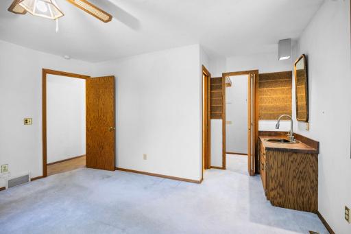 Primary offers a walk-through to main level bathroom and features a private vanity space.