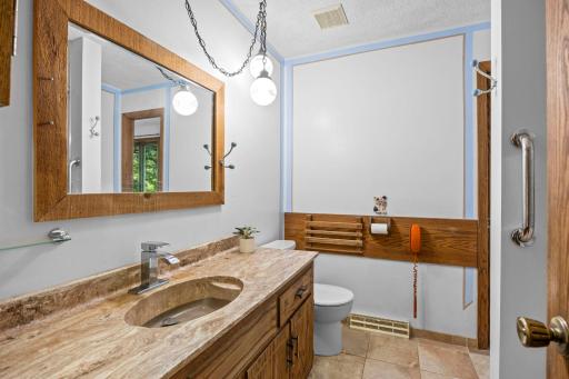 Main level full bathroom offering a walk-through from Primary bedroom.