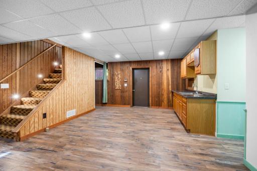 The finished lower level offers flexible bonus space with durable LVP flooring, warm wood accents, and a convenient wet bar with abundant cabinetry and counter space. Ideal for entertaining, a game room, or casual gathering space.