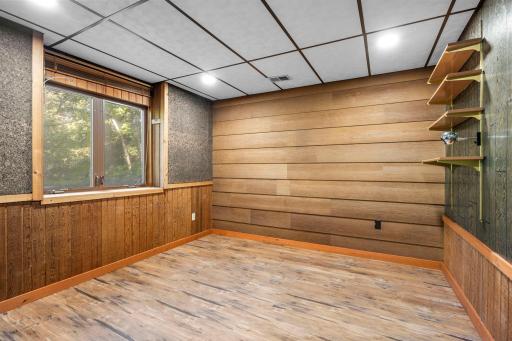 3rd bedroom with warm wood accents, paneled walls.