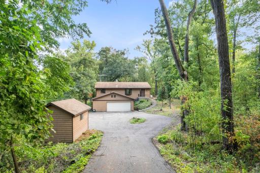 A truly private, wooded setting surrounded by mature trees creates a peaceful retreat with a tucked-away feel. The winding driveway leads to the home, attached garage, and additional outbuilding, all nestled on a 1.7+ acre lot!