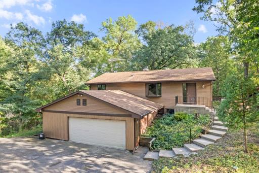 Nestled among mature trees, this distinctive home offers a peaceful, private setting with a welcoming approach.