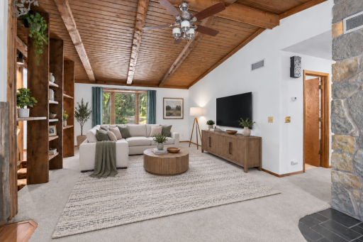 The wood vaulted ceilings are beautiful! Virtually staged to enhance and highlight this fantastic living room space open to kitchen / dining.