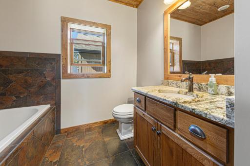 The full ensuite bathroom features a separate tub, a tiled walk-in shower.