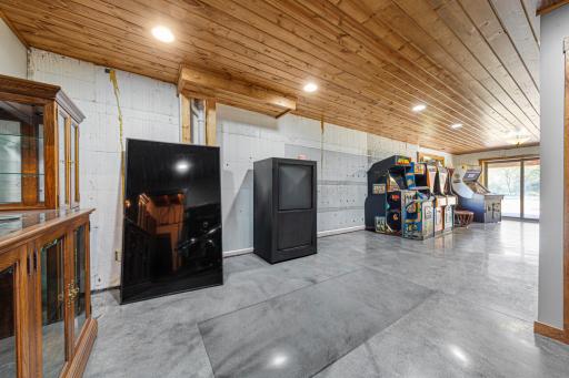 Another view of the family room. The spacious family room features a pine ceiling, recessed canister lighting, and polished concrete floors.
