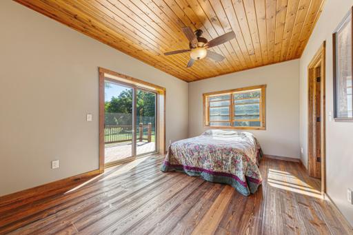 The spacious primary bedroom features a walk-in closet and a private full ensuite bathroom. A sliding patio door leads out to the expansive deck.