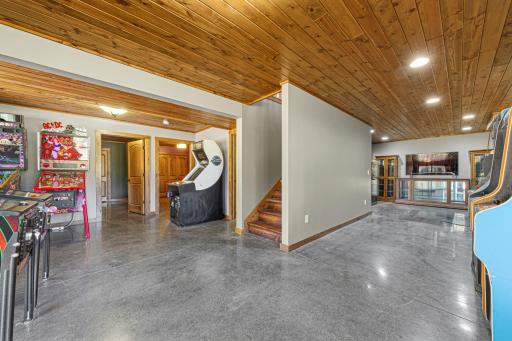 Head downstairs to the family room. The lower level features pine ceilings with recessed canister lighting, in-floor heat, and polished concrete floors.