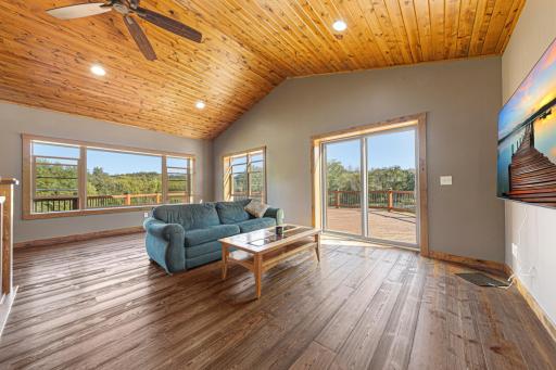The living room stuns with soaring vaulted ceilings and warm hardwood floors.
