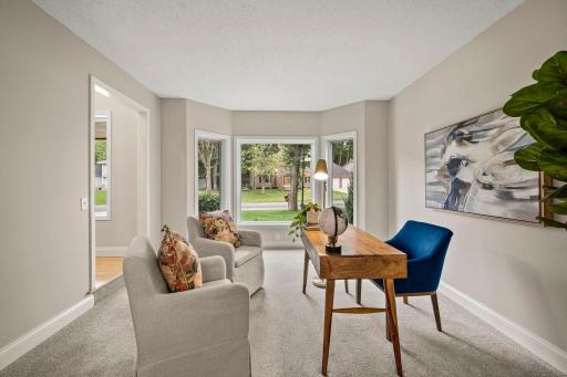 The living room features a bay window overlooking the peaceful front yard.