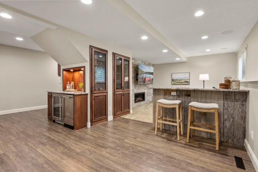 Rich wood cabinetry, counter seating, an ice maker, wine storage, and beverage fridge create a seriously fun setup for everything from casual nights in, to bigger gatherings.