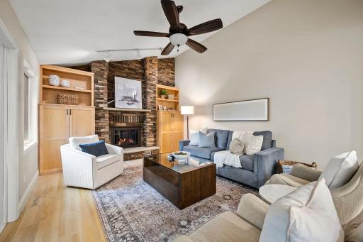 Stunning wood-burning fireplace framed by built-ins and a floor-to-ceiling stone surround!
