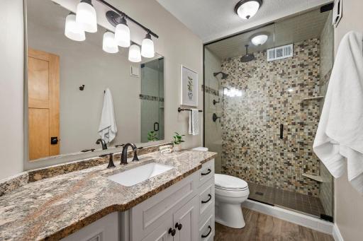 A beautifully finished upper-level bathroom completes the space with a sizable tiled walk-in shower and large vanity with plenty of storage.