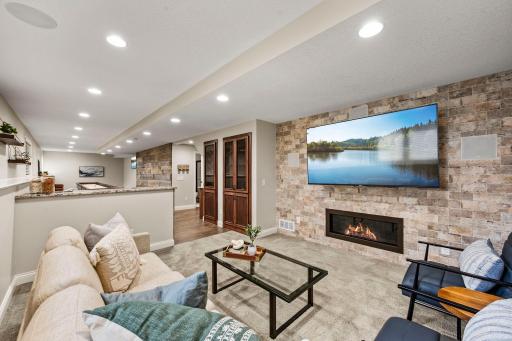A spacious family room features a tile accent wall, surround sound, and built-in entertainment storage.