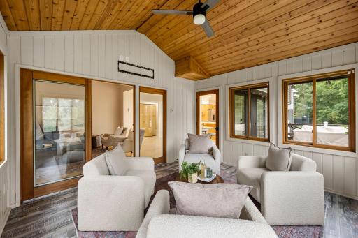 Vaulted wood-paneled ceiling, walls of windows, and a ceiling fan for year-round comfort.