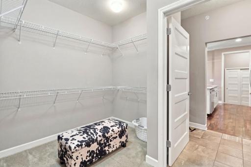 A spacious walk in closet with acess to the laundry & primary suite