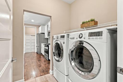 Front load washer dryer for easy access & top folding surface. Wire shelving holds detergents, etc. Not seen is additional shelving for more storage on opposite wall.