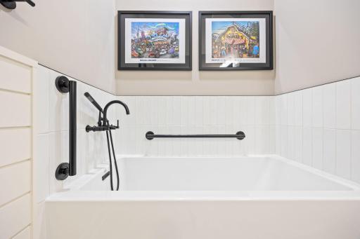Verticle subway tile and hand held bathing wand creates a luxurious bathing expenience