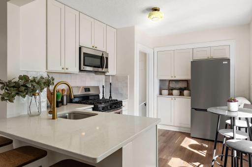 Stunning brand new kitchen with quartz countertops, tile backsplash, and stainless steel appliances