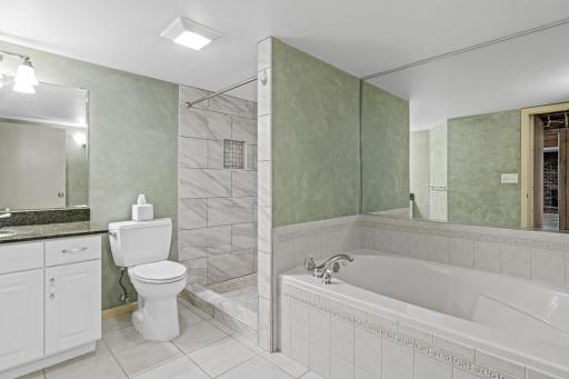 Separate jacuzzi tub for relaxing after a full day. Beautiful tiled shower and abundant space in this updated bathroom.