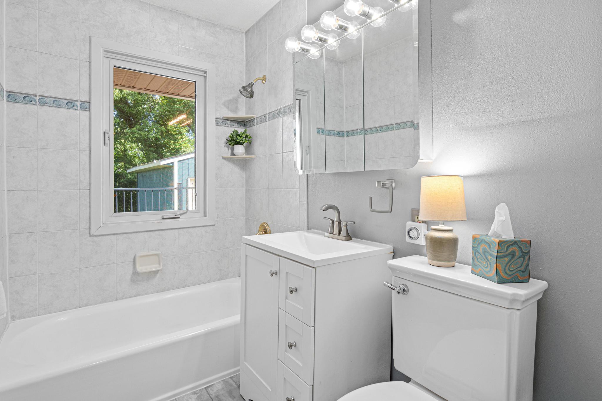 The full bathroom located on the main floor was recently updated and is bright and welcoming. Enjoy views to the nature filled backyard.
