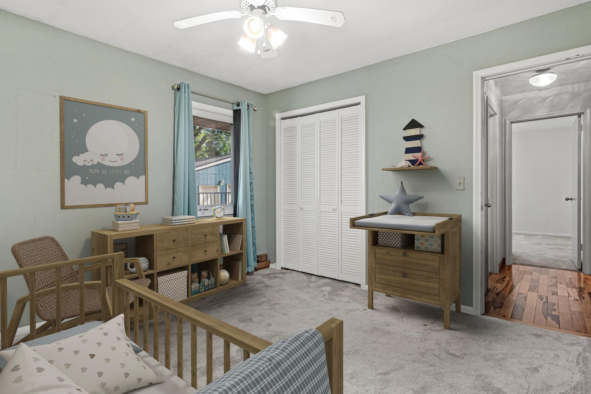 One of three bedrooms on the main level overlooking the beautiful backyard. Visually staged.