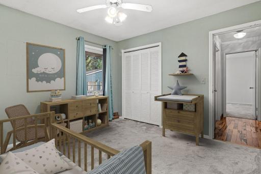 One of three bedrooms on the main level overlooking the beautiful backyard. Visually staged.