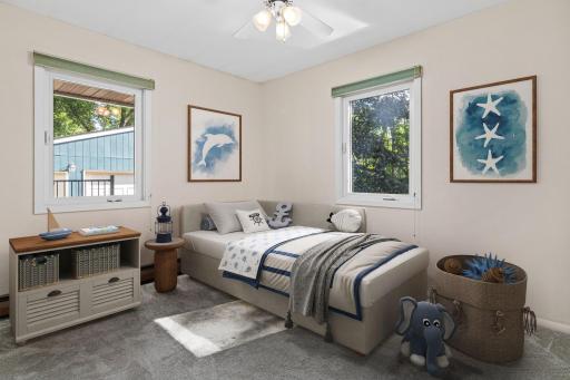 One of three bedrooms on the main level, overlooking the south and east side of the yard. Visually staged.