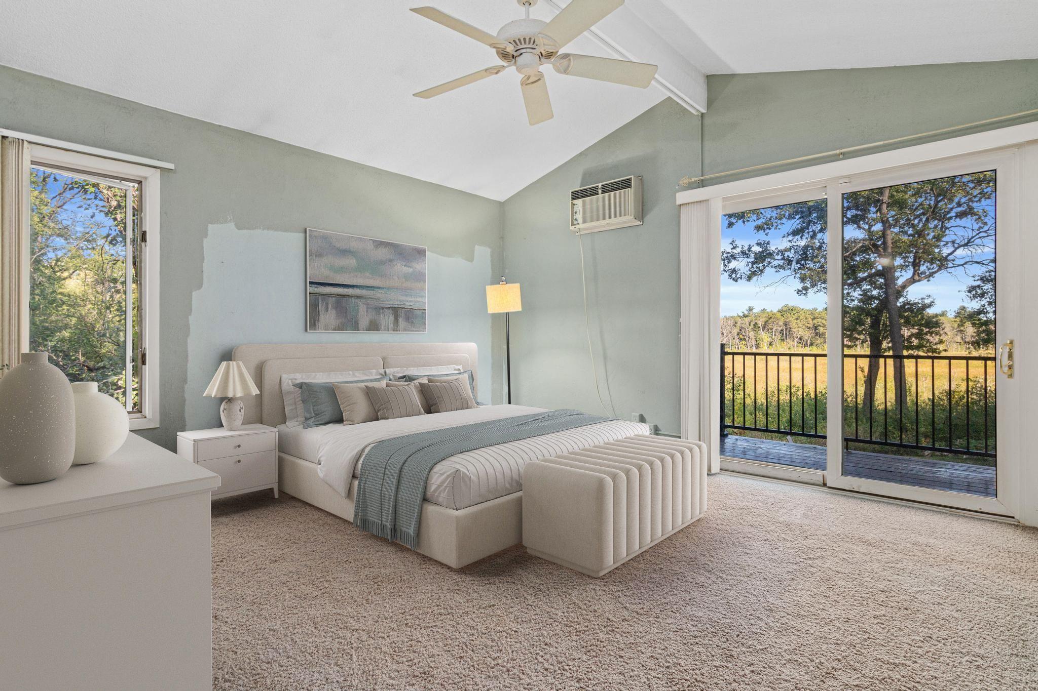 The primary bedroom is a peaceful, private, retreat featuring beautiful views of nature and direct access to the deck, creating a wonderful connection to the outdoors. Visually staged.