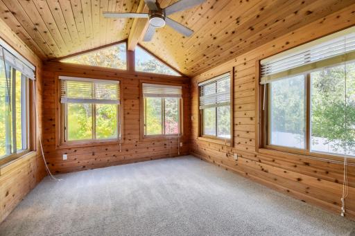 Four season porch with views to the backyard and beautiful tree line in the backyard.