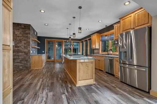 An Inviting Kitchen Space Highlighted By The Rich Warmth Of Exposed Brick, Efficient Double Ovens, And Ample Workspace—Creating A Cozy, Welcoming Environment For Family And Guests To Gather!