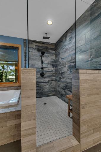 Gorgeous Primary Ensuite Features A Seamless, Step-In Shower, Anchored By A Striking See-Through Window That Floods The Entire Space With Vibrant Natural Daylight!