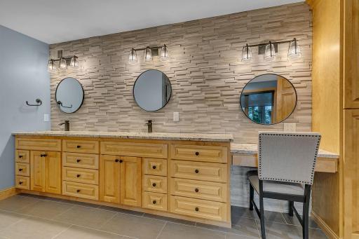 Indulge in a private retreat designed for effortless mornings. Beautifully appointed bath showcases exquisite custom stonework, sleek double sinks, and a dedicated vanity space crafted to give you a personal sanctuary for getting ready in style!