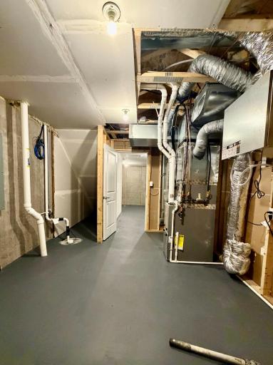 Mechanical room showing sump basket with radon mitigation system and air exchanger.