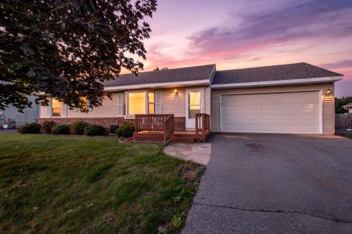 Beautiful curb appeal at sunset! This charming one-level home features an inviting front entry, mature landscaping, and an attached two-car garageâall framed by a picture-perfect evening sky.