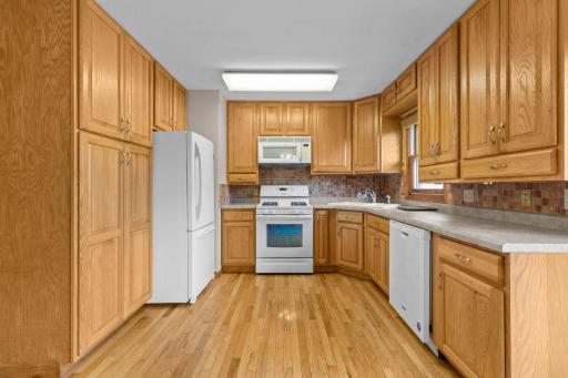 Gleaming hardwood flooring spans the kitchen and dining.