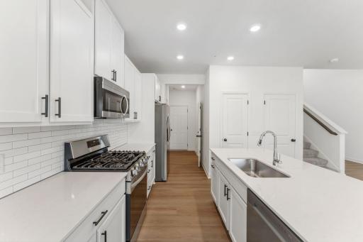 A subway tile backsplash atop the 5-burner gas cooktop with an overhead microwave meets style with functionality