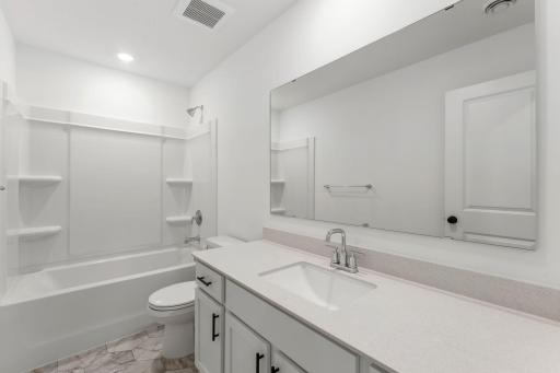 A full-sized bathroom on the second floor comes well-equipped with a generously sized quartz-topped vanity and a combination shower and tub to maximize the interior space.