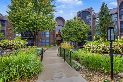 Lush landscaping featuring gardens and ponds welcome visitors.
