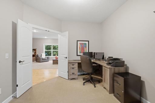 French doors define the office while maintaining an open connection to the main living areas. The generously sized room offers plenty of space for a substantial desk setup, storage and additional office furniture.