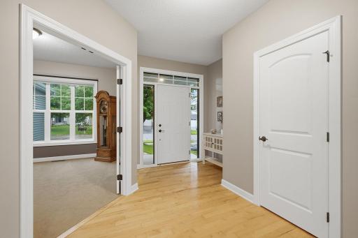 A bright and welcoming foyer features 9-foot ceilings, hardwood flooring, & natural light surrounding the front door. A convenient hallway closet provides everyday storage, while French doors open to a dedicated main-level office just off the entry.