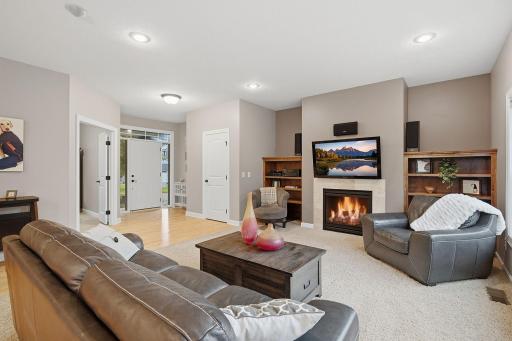 The gas fireplace creates a warm focal point in the living room, complemented by custom built-in shelving on both sides for added character, storage and display space. The generous layout offers plenty of room for multiple seating arrangements.