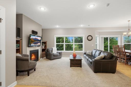 This spacious living room is filled with natural light from an oversized bank of windows overlooking the backyard. Recessed lighting and an open connection to the dining area create a bright, comfortable space for everyday living and entertaining.