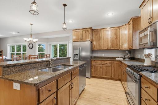 A closer look showcases the kitchenâs functional workspace with abundant cabinetry and counter space, double-basin sink and stainless steel appliances, including a dual-fuel range combining gas cooking with an electric oven.
