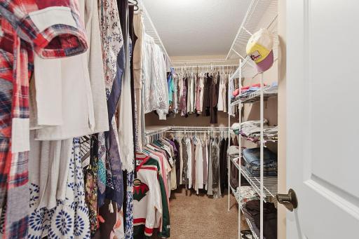 A large walk-in closet offers extensive hanging and shelving space on multiple walls, providing plenty of room for clothing, shoes and accessories.