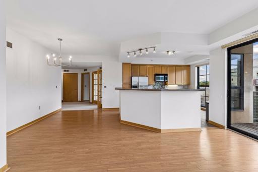 The den is located just beyond the main living spaces to the right and is accessed through double French doors.