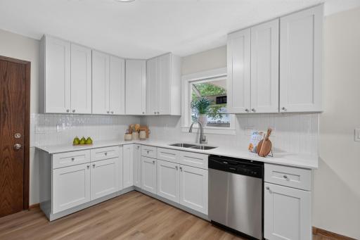 New LVP flooring, cabinets, countertops, tile backsplash and stainless steel appliances